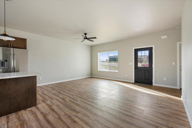 unfurnished living room featuring light hardwood / wood-style floors and ceiling fan