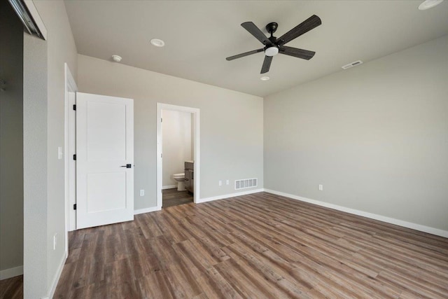 unfurnished bedroom with dark hardwood / wood-style flooring, ensuite bath, and ceiling fan