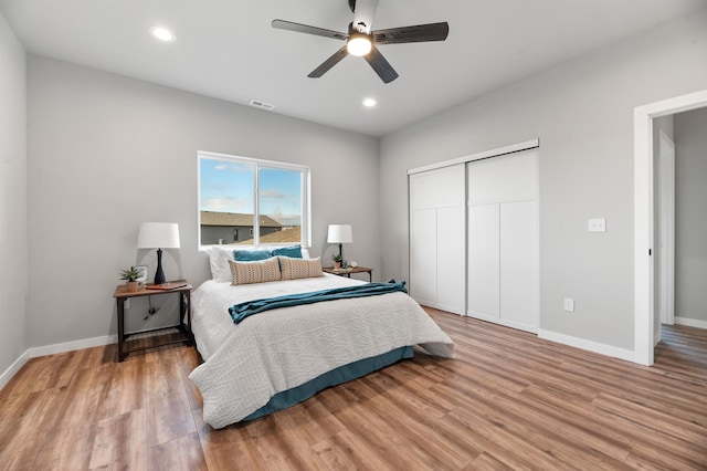 bedroom featuring ceiling fan, a closet, and light hardwood / wood-style flooring