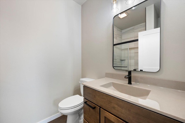 bathroom with vanity, toilet, and walk in shower