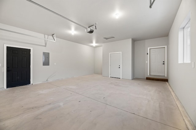 garage with a garage door opener and electric panel