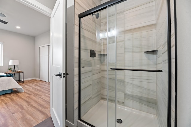 bathroom featuring wood-type flooring and a shower with shower door