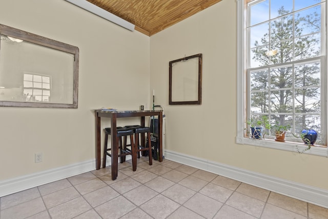 dining space with light tile patterned flooring and wooden ceiling