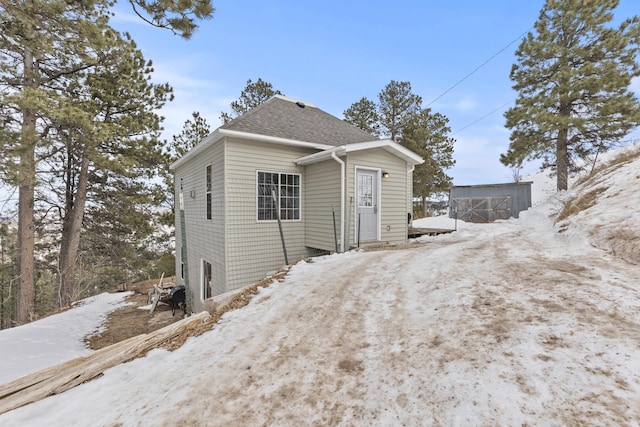 snow covered property featuring an outdoor structure