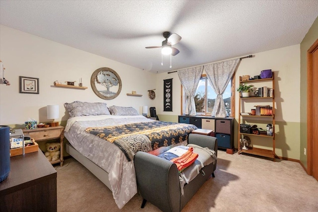 carpeted bedroom with ceiling fan and a textured ceiling