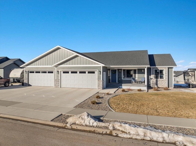 view of front of property featuring a garage, covered porch, and a front lawn