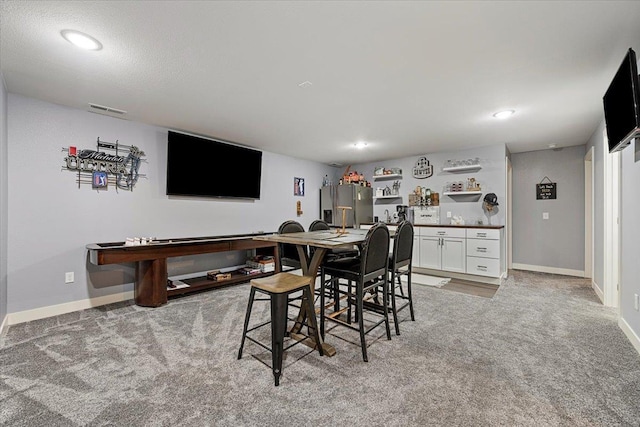 dining area with light carpet and indoor bar