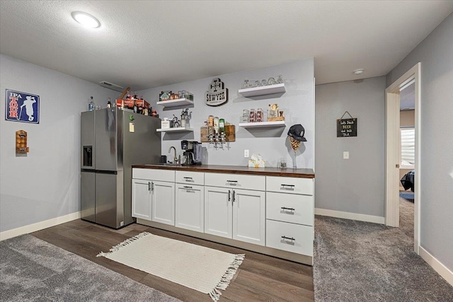 kitchen featuring wood counters, sink, stainless steel fridge with ice dispenser, dark hardwood / wood-style floors, and white cabinets