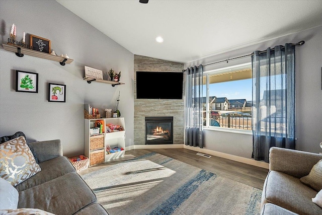 living room featuring lofted ceiling, hardwood / wood-style flooring, and a fireplace