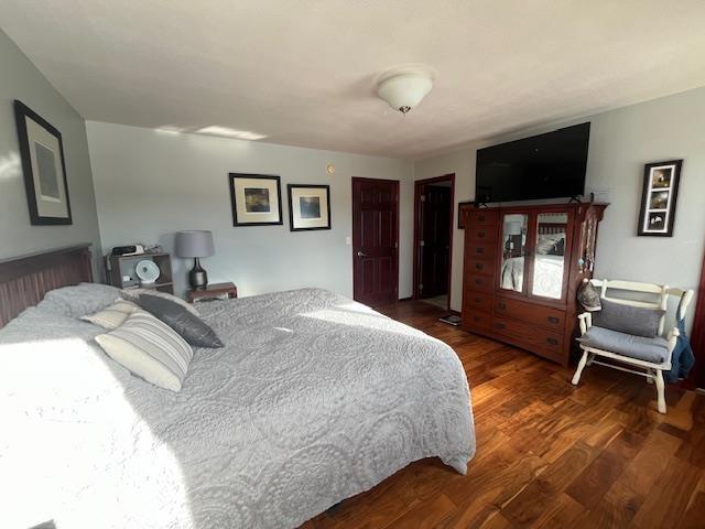 bedroom with dark wood-type flooring