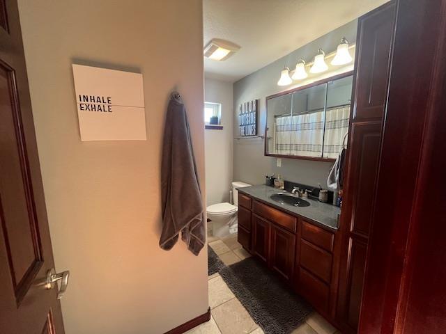 bathroom featuring tile patterned flooring, vanity, and toilet