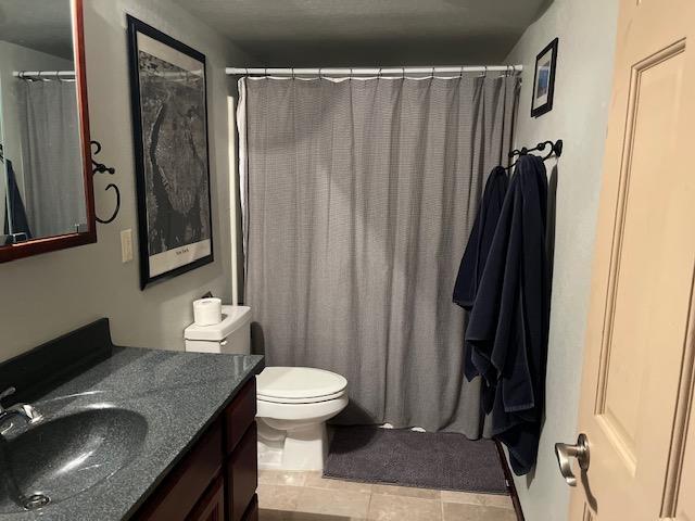 bathroom featuring vanity, tile patterned flooring, and toilet