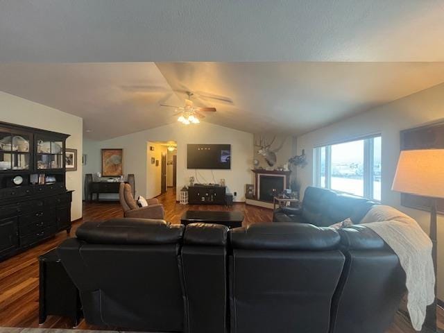 living room with hardwood / wood-style flooring, vaulted ceiling, a fireplace, and ceiling fan