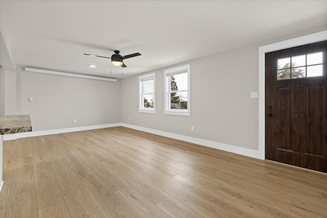 entrance foyer featuring light wood-type flooring, ceiling fan, and a textured ceiling