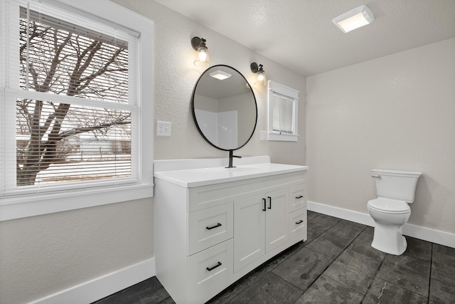 bathroom featuring toilet, a textured ceiling, and vanity