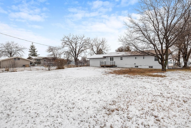 snow covered house featuring a wooden deck