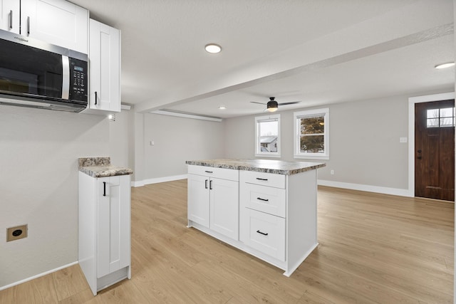 kitchen featuring ceiling fan, light hardwood / wood-style floors, and white cabinetry