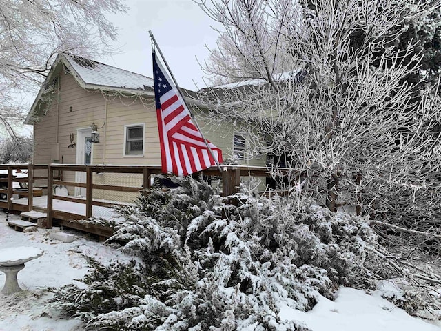 view of snowy exterior featuring a deck