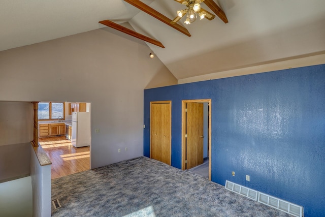 interior space with beamed ceiling, ceiling fan, and high vaulted ceiling