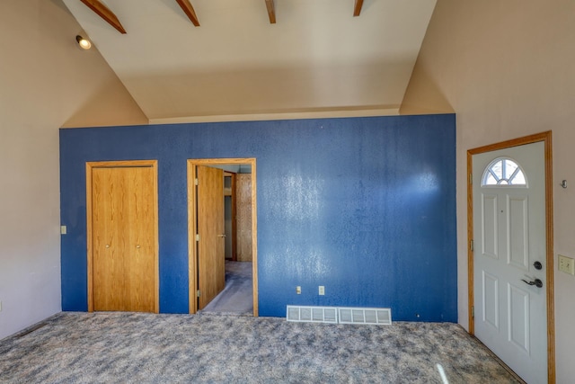 carpeted foyer entrance with vaulted ceiling