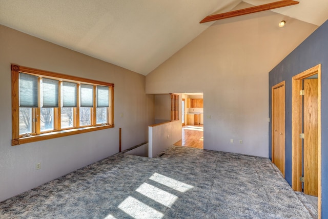 unfurnished bedroom featuring carpet floors and high vaulted ceiling