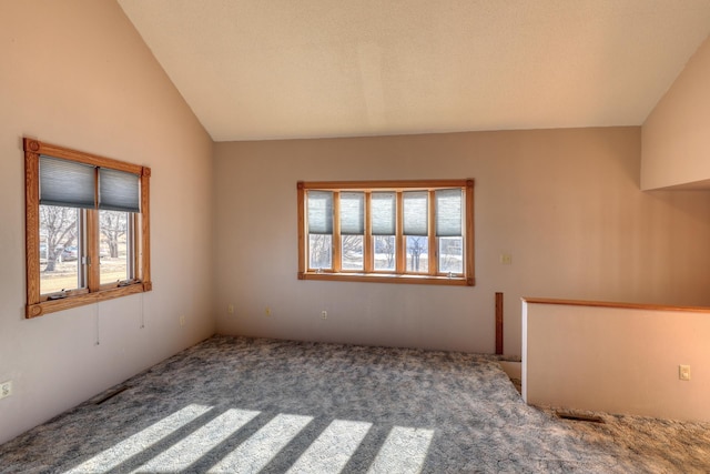 carpeted spare room with lofted ceiling