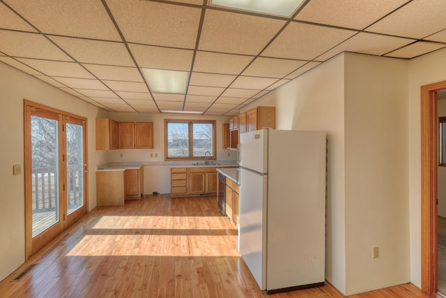 kitchen featuring white fridge, sink, and light hardwood / wood-style floors