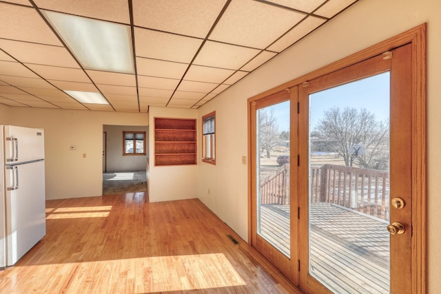 doorway with a drop ceiling and light hardwood / wood-style floors