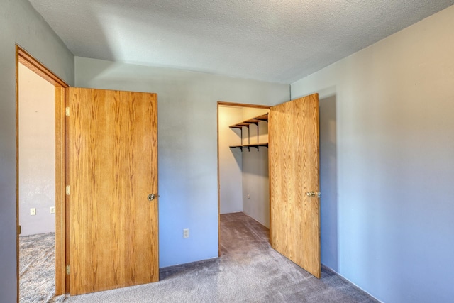 unfurnished bedroom with a closet, a textured ceiling, and carpet flooring