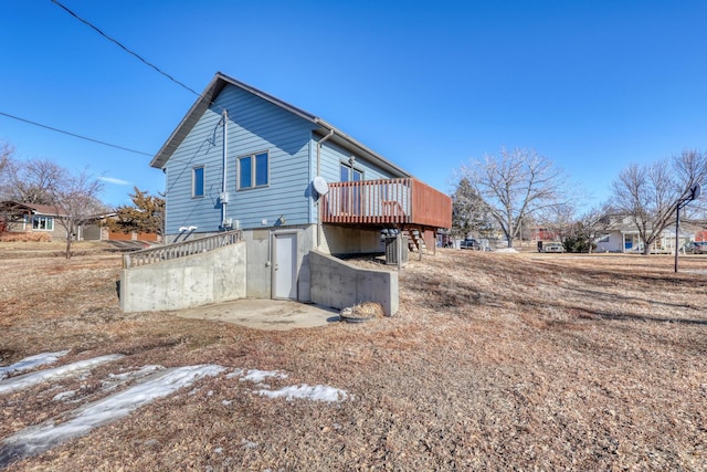 rear view of property featuring a patio and a deck