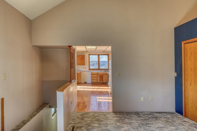 corridor featuring lofted ceiling and light hardwood / wood-style floors