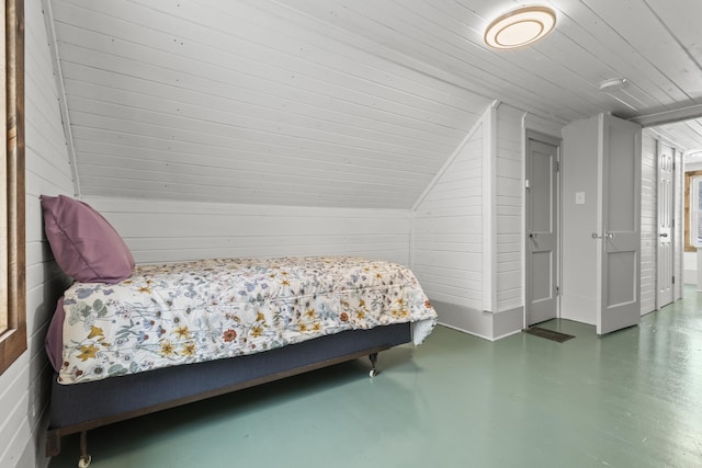 bedroom featuring lofted ceiling, wood ceiling, and wood walls