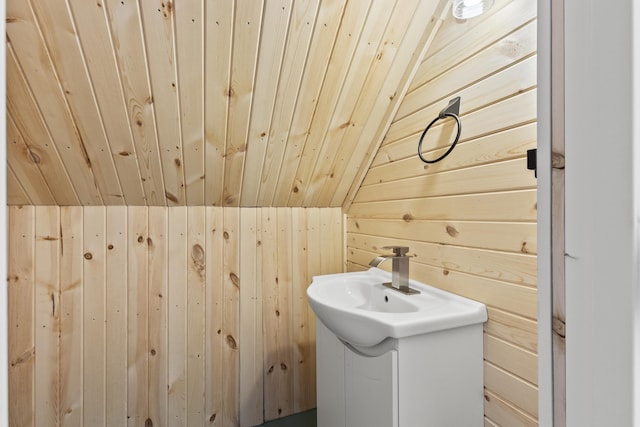 bathroom with lofted ceiling, vanity, wooden walls, and wooden ceiling