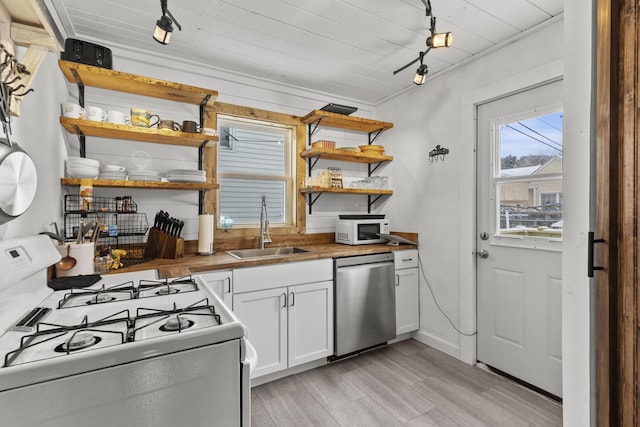 kitchen with sink, white appliances, wooden counters, white cabinetry, and light hardwood / wood-style floors