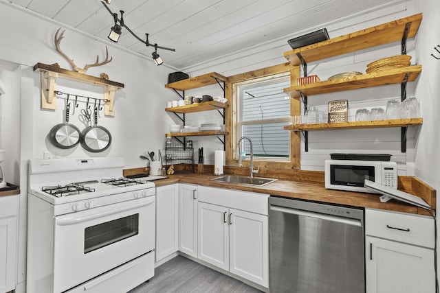 kitchen featuring butcher block counters, sink, light hardwood / wood-style flooring, white appliances, and white cabinets