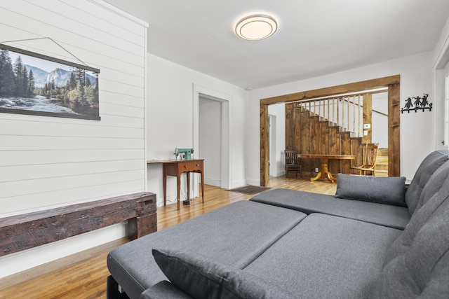 living room featuring hardwood / wood-style flooring and wooden walls