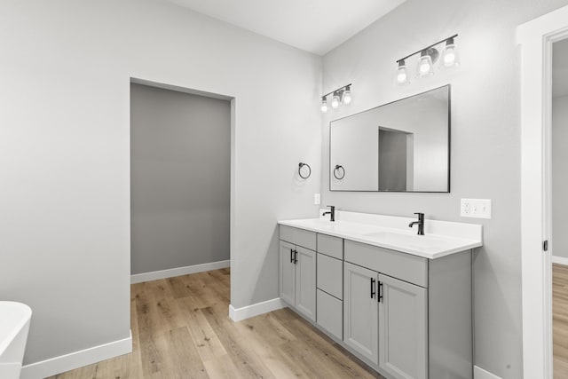 bathroom featuring vanity, a bath, and hardwood / wood-style floors
