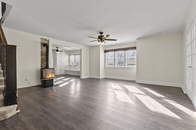 unfurnished living room with hardwood / wood-style floors, ceiling fan, and a wood stove