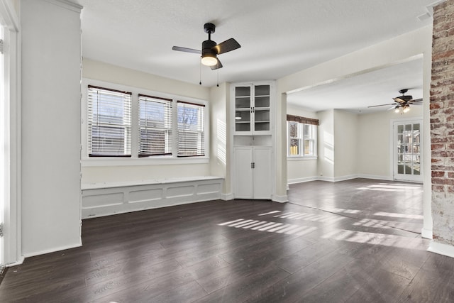 spare room with dark hardwood / wood-style floors, a textured ceiling, and ceiling fan