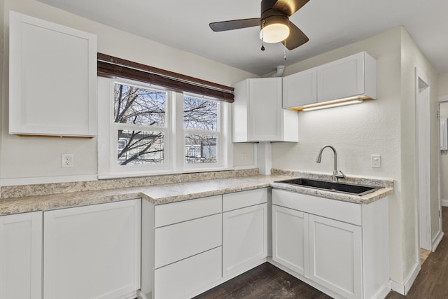 kitchen with dark hardwood / wood-style flooring, sink, white cabinets, and ceiling fan