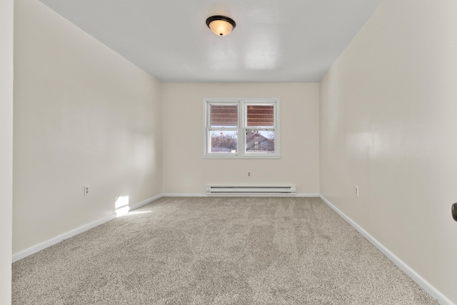 spare room with baseboard heating and light carpet