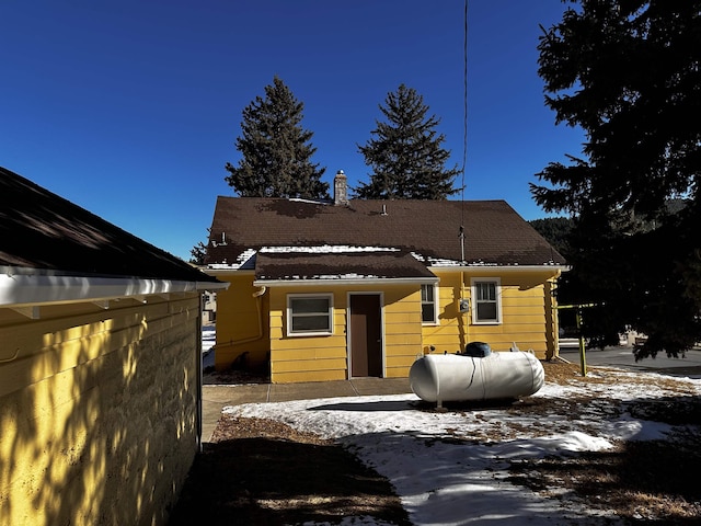 133 Pine Ave, Hill City, SD 57745 - snow covered back of property featuring a chimney