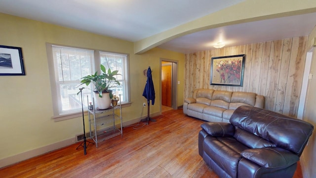 133 Pine Ave, Hill City, SD 57745 - living area with arched walkways, light wood finished floors, wood walls, baseboards, and beam ceiling