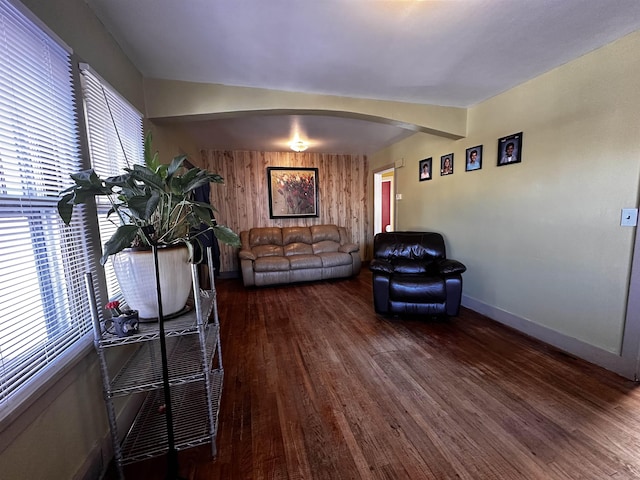 133 Pine Ave, Hill City, SD 57745 - living room with arched walkways, wood finished floors, baseboards, and wood walls