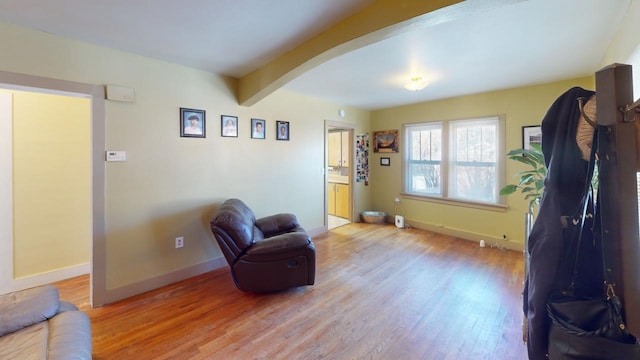 133 Pine Ave, Hill City, SD 57745 - living area with baseboards, wood finished floors, arched walkways, and beamed ceiling