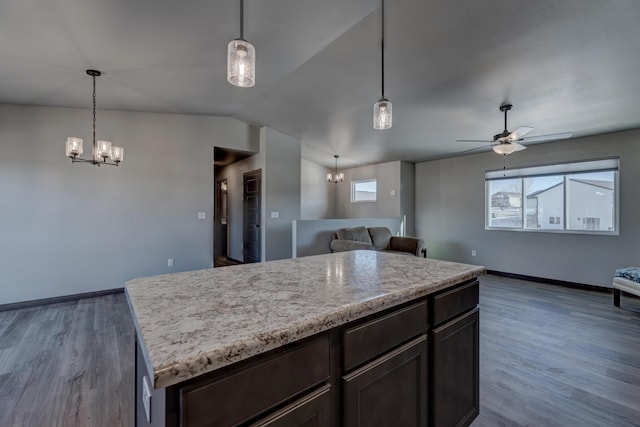 kitchen featuring dark brown cabinetry, dark hardwood / wood-style floors, hanging light fixtures, and a kitchen island