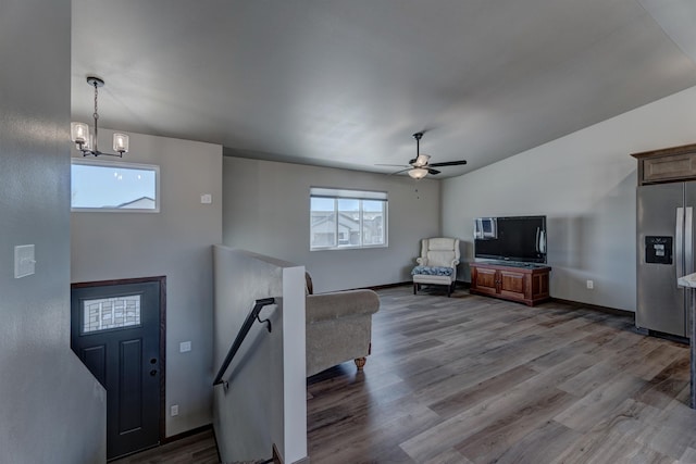 entryway featuring lofted ceiling, ceiling fan with notable chandelier, a wealth of natural light, and light hardwood / wood-style floors