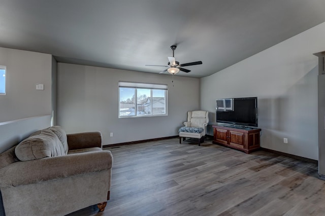 living area featuring vaulted ceiling, light hardwood / wood-style floors, and ceiling fan