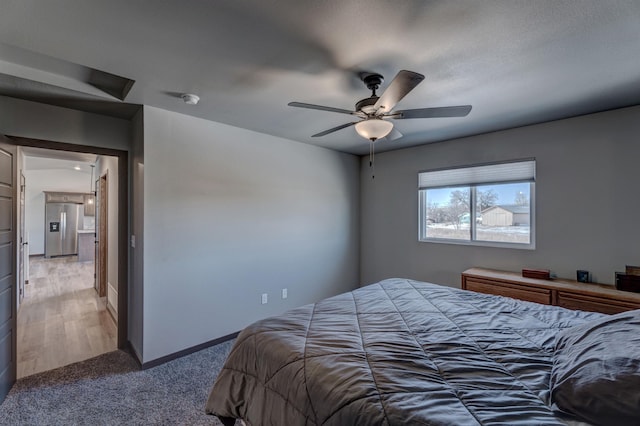 bedroom featuring carpet floors, ceiling fan, and stainless steel fridge with ice dispenser