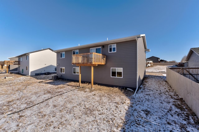 rear view of property featuring a balcony and central AC unit